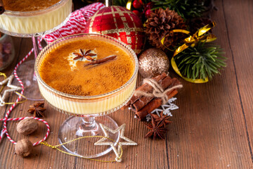 Traditional Christmas Eggnog Martini Or Brandy Alexander Cocktail with cinnamon and nutmeg, with golden Christmas decorations and bokeh effect, copy space