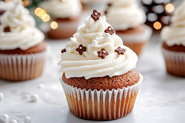 Close-up of a spice christmas cupcake with a tall swirl of white frosting, decorated with small chocolate flower cutouts and sugar pearls. Warm and cozy festive dessert atmosphere