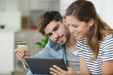smiling happy couple couple buying online with tablet pc computer