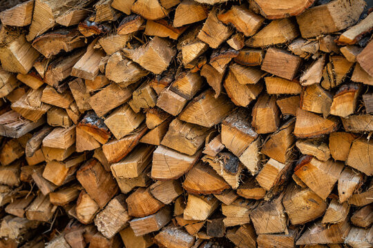 Stack of winter firewood logs for fireplace burning in ski resort provided by Homeowner Association with pattern of wood