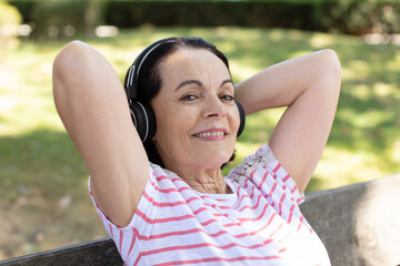 portrait of senior woman at the park listening to music
