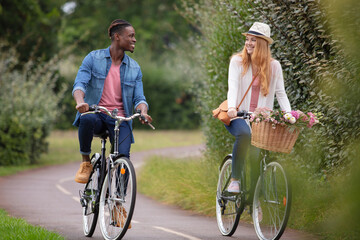 Fototapeta premium mixed-race couple cycling along cycle track