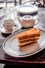 Tea time in a café with carrot cake on a wooden table