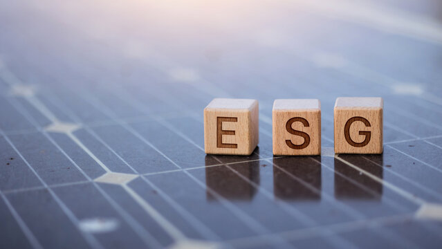 ESG wooden cubes on solar panel for renewable energy and sustainability concept.