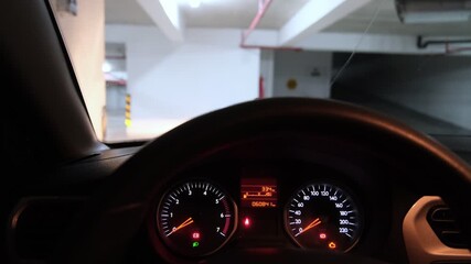 Modern car dashboard with illuminated speedometer and tachometer starting up inside a parking lot - Powered by Adobe