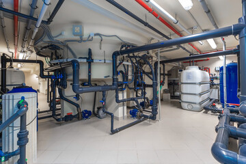 Complex network of pipes and equipment in a modern utility room showcasing advanced plumbing design...
