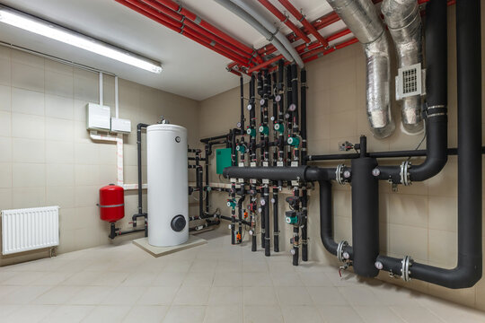Utility room features a variety of pipes, a water heater, and fittings for managing water flow and heating. The organized setup demonstrates efficient plumbing design and maintenance.