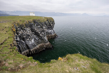 Arnarstapi Lighthouse on the coastal cliffs with curved basalt rock pillars and nesting seabirds, Arnarstapi, Snaefellsnes Peninsula, West Iceland