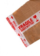 Brown wrapping paper with FRAGILE packing tape on a white background.