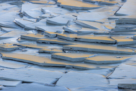 View of glittering ice fragments, scattered like fractured jewels, reflecting a warm sunset glow on the frigid waters in Jokulsarlon, Sveitarfelagid Hornafjordur, Iceland.