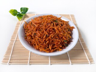 Kentang Mustofa, Indonesian crispy spicy potato strips served in a white plate on bamboo mat.