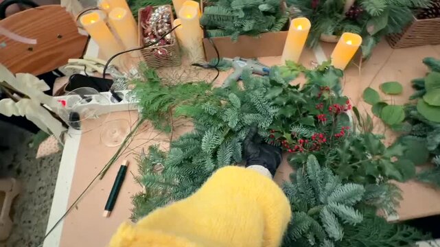 caucasian decorator adding berries and foliage for wreath finish