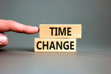 Time change symbol. Concept word Time change on beautiful wooden blocks. Beautiful grey paper background. Businessman's hand. Business time change concept. Copy space.