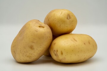 Three fresh potatoes isolated on white background