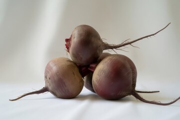 Three fresh beets with roots and stems isolated on white background
