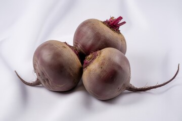 Three fresh beetroots with green tops isolated on white background