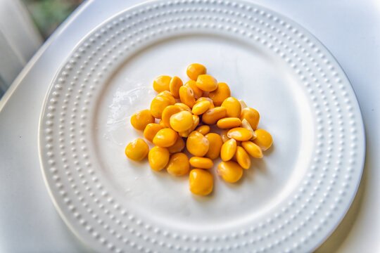 Lupini beans snack on white plate background macro closeup, healthy Mediterranean food appetizer