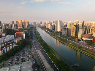 aerial view of Pinheiros river in Sao Paulo city with skyline in the distance during sunset