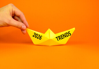 2026 Trends new year symbol. Concept words 2026 Trends on beautiful yellow paper boat. Beautiful orange paper background. Businessman's hand. Business and 2026 Trends new year concept. Copy space.