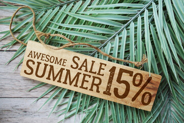 Awesome Summer Sale 15% off with green leaf on wooden background