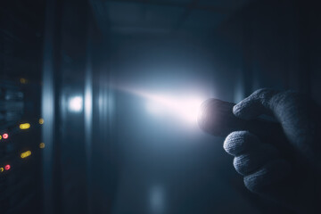 Data breach in server room is depicted with gloved hand holding flashlight illuminating dark racks creating tense and mysterious atmosphere