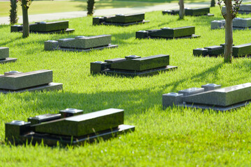 日本の芝生墓地の洋型墓石のある霊園の風景。