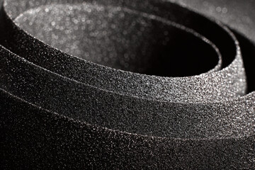 close up abstract texture of dark abrasive sandpaper roll