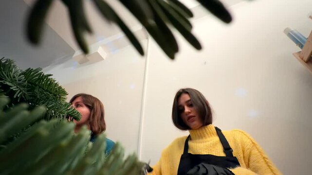 caucasian duo finishing wreath from low angle, action shot