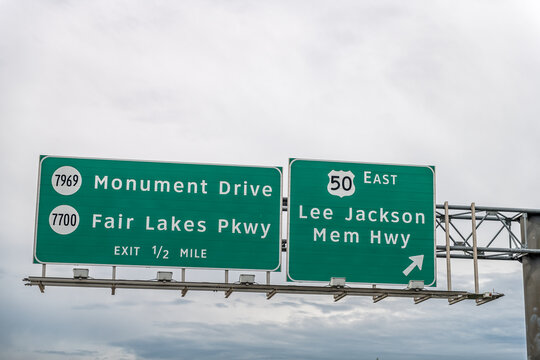 Fairfax county highway in Northern Virginia with exit isolated sign against cloudy sky for east Lee Jackson Memorial Highway and Monument drive