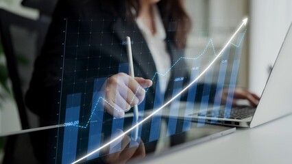 A businesswoman reviews data trends on her laptop, using a digital graph visualization. This scene captures the essence of financial planning and analytical growth in a modern office. Copula