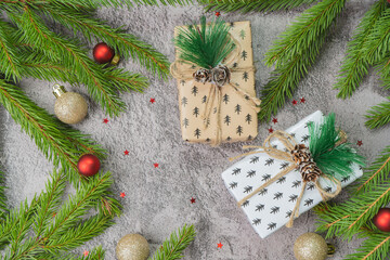 Christmas composition. Gift boxes, fir tree branches, red and gold decorations on grey background. High quality photo