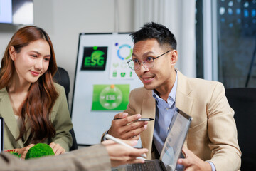 Asian business professionals collaborating in a corporate meeting, reviewing sustainability reports and environmental, social, governance strategies