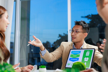 Asian business professionals discussing Environmental, Social, and Governance - ESG - strategy during a corporate meeting in a modern office