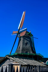 Traditional black wooden architecture and windmill at Zaanse Schans museum village.