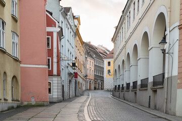 Fototapeta premium Narrow empty street in Görlitz with pastel historic buildings and archways, creating a classic European old-town atmosphere.