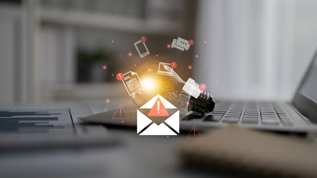 A close-up view of a laptop displaying an alert notification with digital icons representing emails and messages, illustrating modern communication in a workspace. Gantry - Powered by Adobe