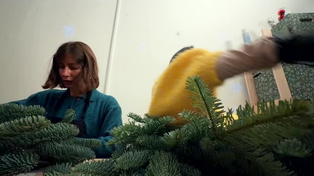 Wrapping and preparing wreaths for market sale at bench
