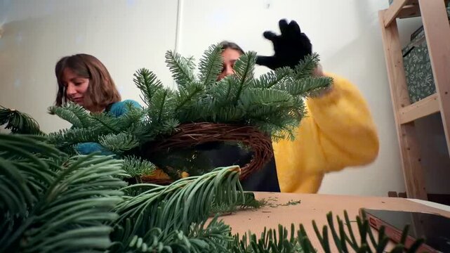 Worker assembling wreath frame with grapevine and branches