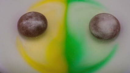 Candy dissolving in colorful liquid creating abstract patterns