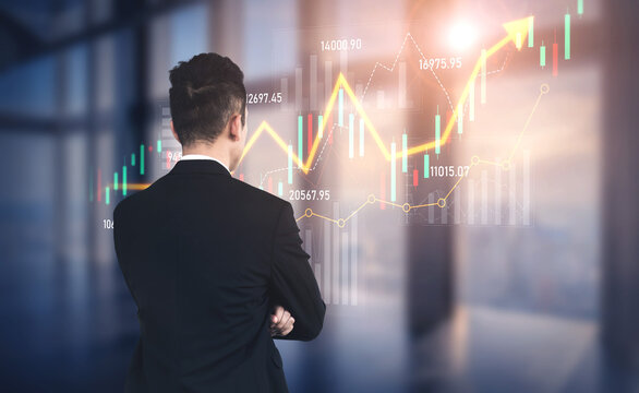A businessman stands in a modern office, analyzing rising stock market trends represented by a financial graph, symbolizing investment growth and professional insight. Scalp