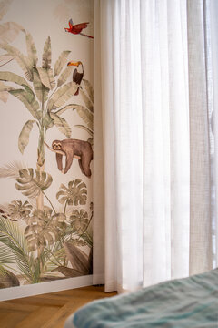 Fototapeta Tropikalna tapeta z motywem roślin i zwierząt w jasnym, przytulnym wnętrzu