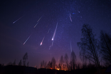 Mesmerizing Meteor Shower Over Trees. Meteor shower streaking across a starry night sky. Ideal for astronomy events or nighttime themes.