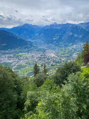 Scenic view over Merano (Meran) and the Burgraviato in the Adige Valley, Italy, with the Vinschgau (Val Venosta) and the Oetztal Alps beyond; towns, orchards and mountains under a cloudy sky