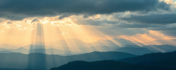 Natural light beams illuminate mountain landscape at sunrise creating a serene atmosphere