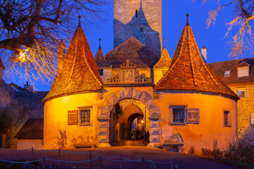 Medieval Roeder Gate in Rothenburg ob der Tauber Germany at sunset with warm lighting