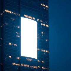 Blank illuminated advertising display on a modern city skyscraper at dusk, ideal for urban ad mockups and promotional designs