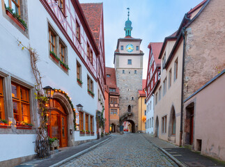 Fototapeta premium Roeder Arch and Markus Tower in Rothenburg ob der Tauber Germany at dawn with holiday lights