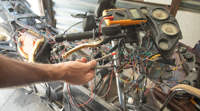 Caucasian electric repairing motorcycle electrical system. - Powered by Adobe
