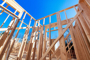 New wooden beams framework rising for house construction project .