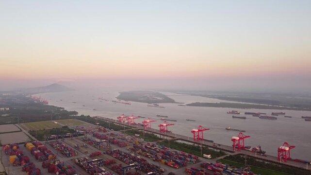 Aerial View of Longtan Port Container Terminal in Nanjing China with Red Cranes and Cargo Ships at Sunset
